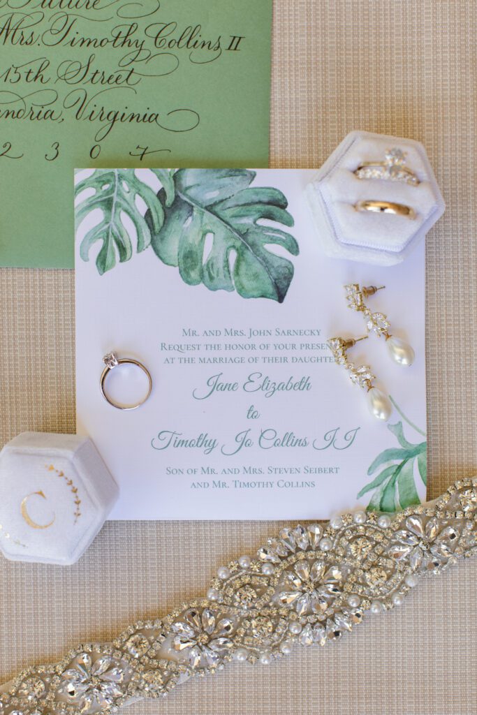 the wedding and engagement rings on top of the wedding invitation