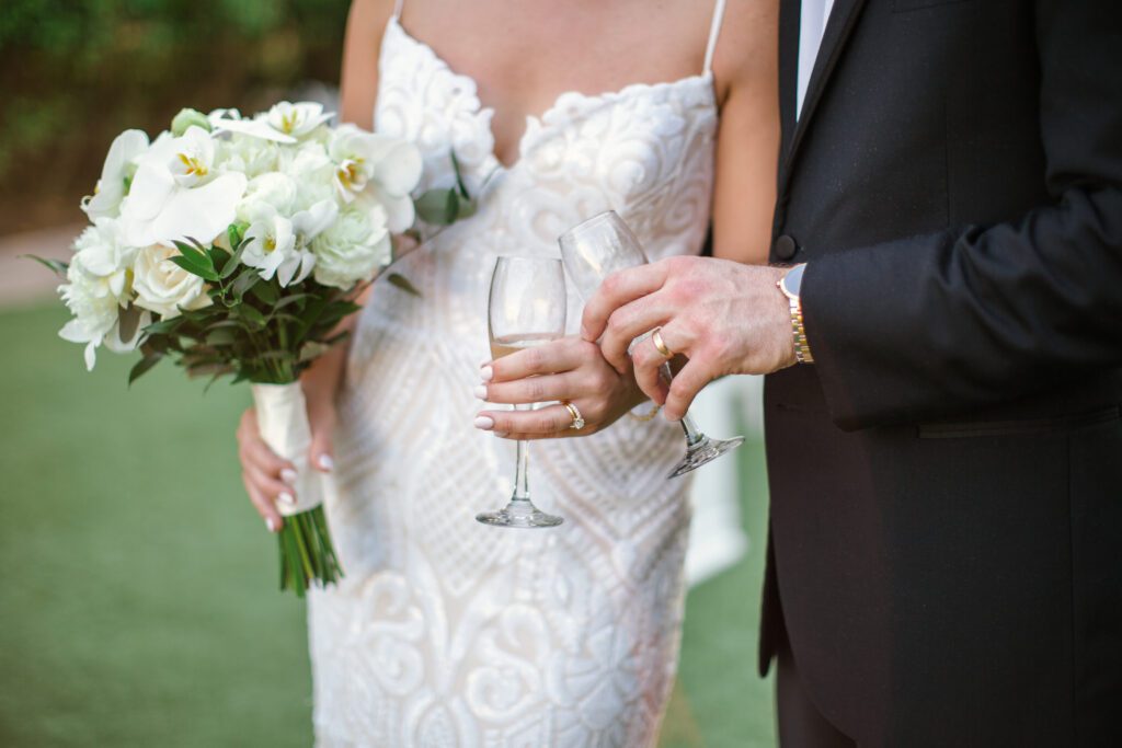 the bride and groom holding wine glasses